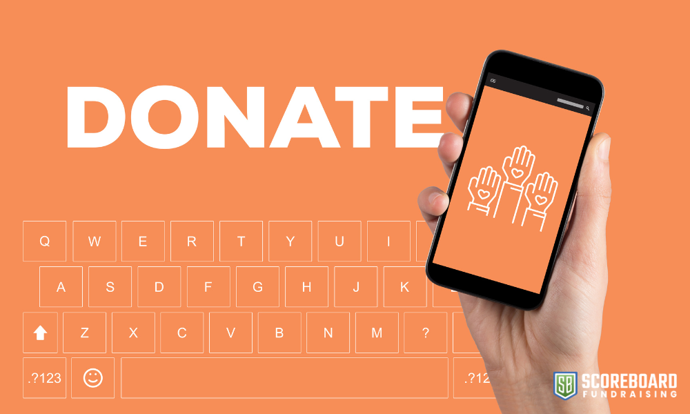 The word donate with a hand holding a cell phone.
