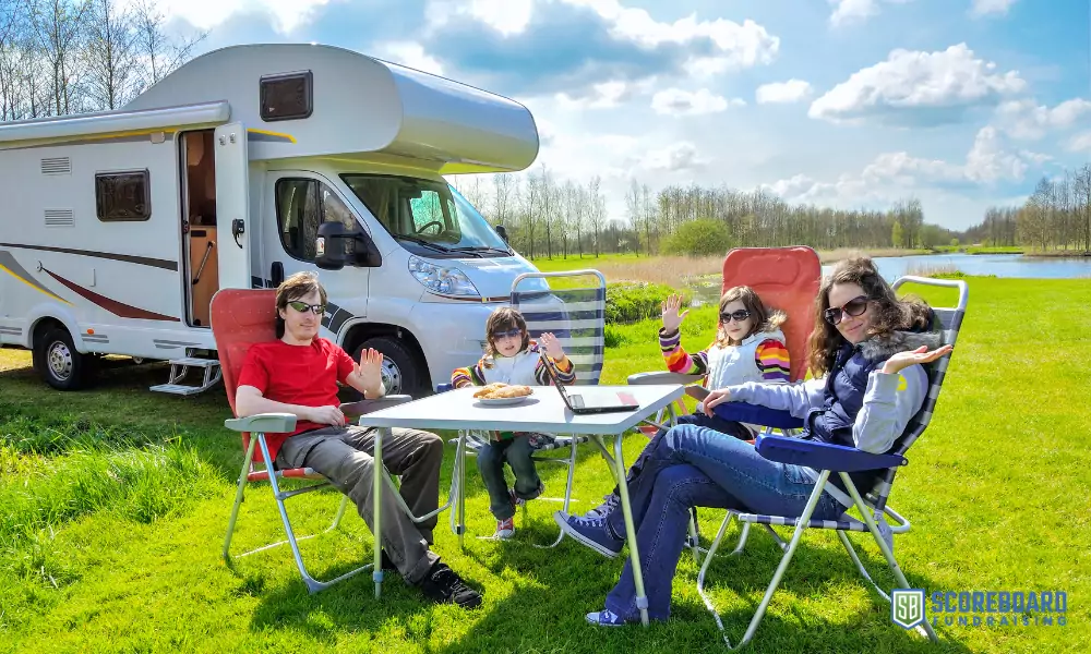 Family eating snacks in front of their camper.